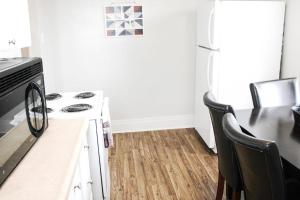 a kitchen with a stove and a table with chairs at Steps Away From Hospital - 2 Queen Bed - City View in Pittsburgh