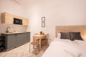 1 dormitorio con 1 cama, cocina y mesa en A20- Boutique Apartments, Best Location. By BQA, en Budapest