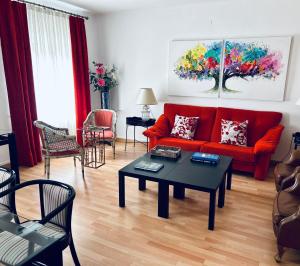 een woonkamer met een rode bank en een tafel bij Casa de la Playa in Vega de Espinareda