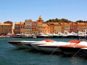two boats are docked in the water next to buildings at Les Tropéziennes in Cogolin