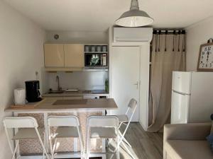 a kitchen with a table and chairs in a room at Les Tropéziennes in Cogolin