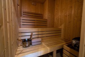 uma sauna de madeira com um balde e toalhas em Stawowa Premium Apartment - 69 m2 with sauna and private garage em Cracóvia