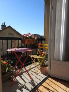 balkon ze stołem i krzesłami na ganku w obiekcie Les Marmottes w mieście Arpajon-sur-Cère