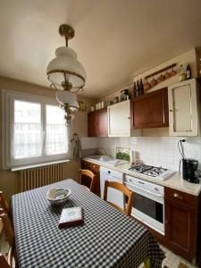 uma cozinha com uma mesa e um fogão forno superior em Les Marmottes em Arpajon-sur-Cère