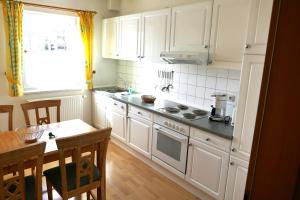 a kitchen with white cabinets and a table and a window at Haus Bergblick in Frauenwald