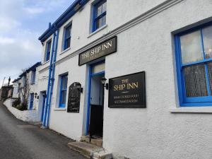 a building with a sign for the shop inn at The Ship Inn in Truro