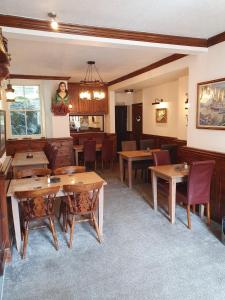 The Ship Inn في ترورو: غرفة طعام مع طاولات وكراسي خشبية