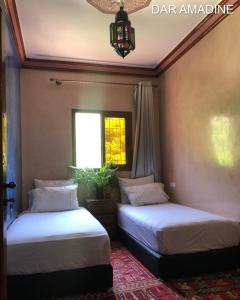 two beds in a room with a window at Dar Amadine in Imlil