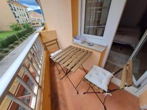 um banco de madeira sentado numa varanda com uma janela em Apartamento de 120m2 al lado de Cabarceno em Sarón