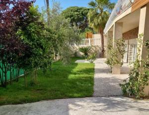 een huis met een tuin met groen gras en bomen bij Villa Jasmine - Cannes in Cannes