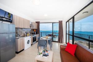 a kitchen and living room with a view of the ocean at Islet Promenade Seafront Apartment with large Corner Terrace by Getawaysmalta in St Paul's Bay +35 photos
