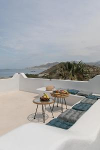 un patio con 2 mesas y vistas al océano en Villa Jardin De Stelida, en Stelida