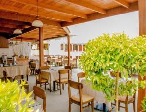 a restaurant with wooden ceilings and tables and chairs at Hotel Curasi in Ica