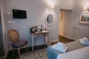 Pokój hotelowy ze stołem i lustrem w obiekcie La Casa di Alma Luxury rooms w Katanii