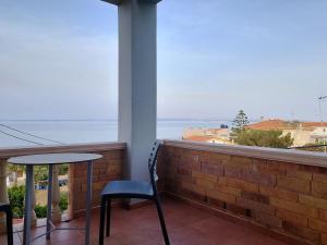 卡法斯的住宿－Chios Shallow Sea，阳台配有桌椅,享有海景。