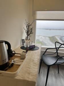 cocina con mesa, cafetera y silla en Hotel Costanera, en Puerto Natales