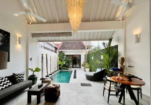 ein Wohnzimmer mit einem Pool und einem Tisch in der Unterkunft Villa Kali in Seminyak