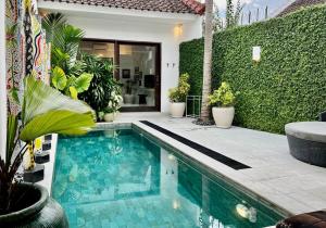 een zwembad voor een huis met planten bij Villa Kali in Seminyak