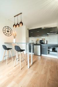 uma cozinha com duas cadeiras e uma bancada em LES DUNES Studio Cosy-Terrasse-Parking -Proche paris em Vitry-sur-Seine