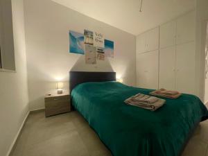 a bedroom with a green bed and a night stand at Sparkling dream in Saronida
