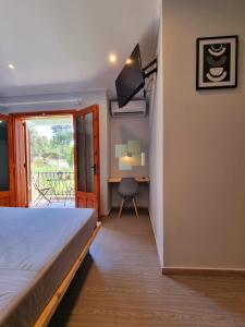 a bedroom with a bed and a desk and a window at Hotel Karagiannis in Limenaria