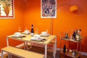 a dining room with orange walls and a table with wine glasses at Stylish 2Bed Apt in Leeds - Free Parking! in Headingley