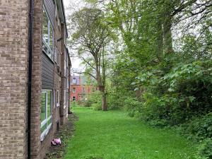 un callejón vacío entre dos edificios de ladrillo con árboles en Stylish 2Bed Apt in Leeds - Free Parking!, en Headingley
