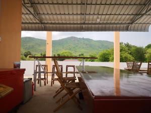 uma cozinha com mesa e cadeiras e uma grande janela em Pottery Garden Villa em Phumĭ Dêk Dŏl