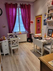 a kitchen with tables and chairs and purple curtains at Le Relais De L'Aube in Villers-Bretonneux