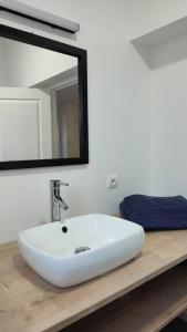 een badkamer met een witte wastafel en een spiegel bij La Villamour avec jacuzzi in Gigean