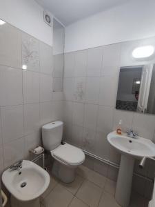 a white bathroom with a toilet and a sink at Aconchegante T3 em Telheiras in Lisbon