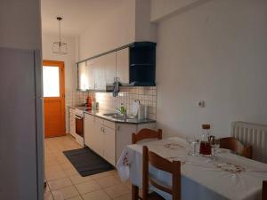 a kitchen with a table and a kitchen with white cabinets at Aegean Star in Apróvaton