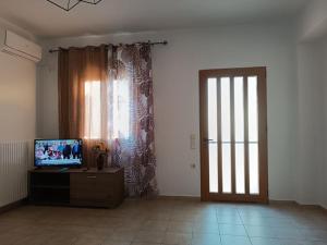 a living room with a door with a television and a television at Aegean Star in Apróvaton