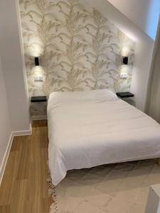 um quarto com uma cama branca e uma parede em Superbe appartement neuf 4 couchages , proche Paris em Bagnolet