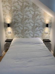 a bedroom with a large white bed with a wallpaper at Superbe appartement neuf 4 couchages , proche Paris in Bagnolet