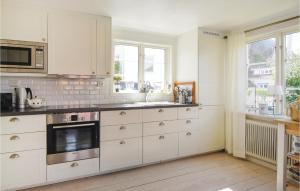 a kitchen with white cabinets and a stove top oven at Nice Home In Bovallstrand With 3 Bedrooms And Wifi in Bovallstrand