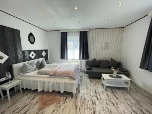 a bedroom with a bed and a couch at LA Boutique House in Füssen