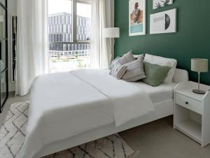 un letto bianco in una stanza con finestra di First Class 1BR Apartment in Dubai Hills - next to Dubai Hills Mall a Dubai