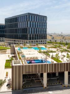 an overhead view of a large building with pools at First Class 1BR Apartment in Dubai Hills - next to Dubai Hills Mall in Dubai