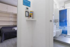 リド・ディ・オスティアにあるAppartamento Federicaのベッドルーム1室(ベッド1台付)、バスルーム(トイレ付)