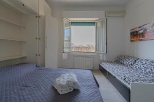 リド・ディ・オスティアにあるAppartamento Federicaのベッドルーム1室(ベッド2台、窓付)