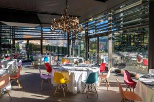 een eetkamer met tafels en stoelen en een kroonluchter bij Parc Hotel Billia in Saint Vincent