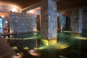a swimming pool in a building with a stone wall at Parc Hotel Billia in Saint Vincent