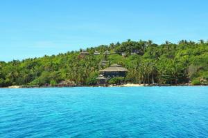 an island with houses on a hill with blue water at Breve Azurine Lagoon Resort in Karimunjawa