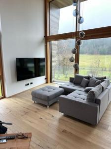 - un salon avec deux canapés et une grande fenêtre dans l'établissement Tolle Bergvilla im Osterzgebirge, à Kurort Altenberg