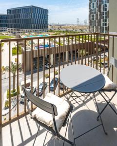 a table and chairs on a balcony with a view of a parking lot at First Class 1BR Apartment in Dubai Hills - next to Dubai Hills Mall in Dubai