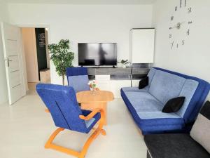 sala de estar con 2 sillas azules y mesa en Apartment Sophie 3 rooms, 2 bathrooms, 8 persons, en Cracovia