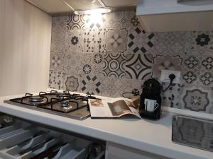 - une cuisine avec une cuisinière et un livre sur un comptoir dans l'établissement Borgo Saraceno Primo, à Sambuca di Sicilia
