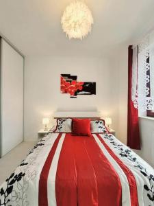 Un dormitorio con una cama roja y blanca con una lámpara de araña en Apartment Sophie 3 rooms, 2 bathrooms, 8 persons, en Cracovia