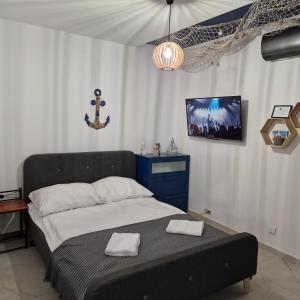 sypialnia z łóżkiem z telewizorem na ścianie w obiekcie Apartament Króla Sielaw - Mikołajki w mieście Mikołajki